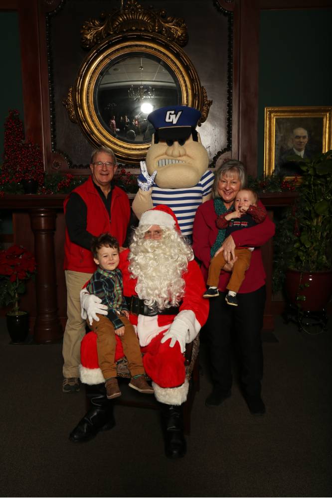 Grandparents and two grandchildren posing with Santa and Louie
